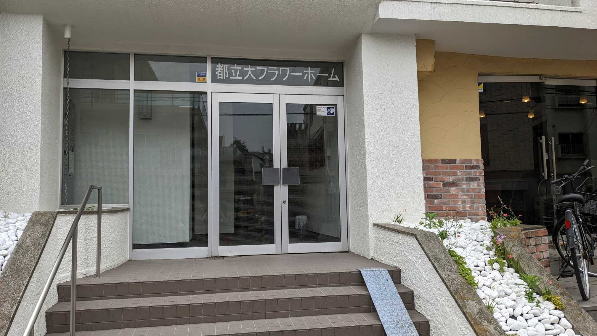 The entrance of Makoto's apartmnet building, a doorway at the top of some steps.