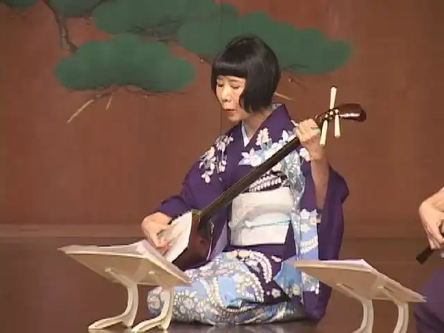 Makoto Nishimura plays the shamisen in a purple kimono