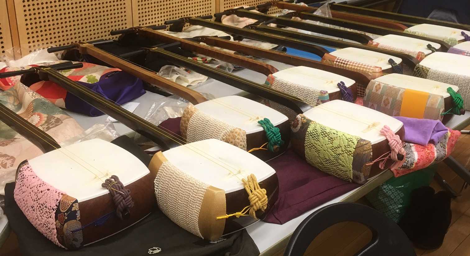 Several shamisen lined up on a table.